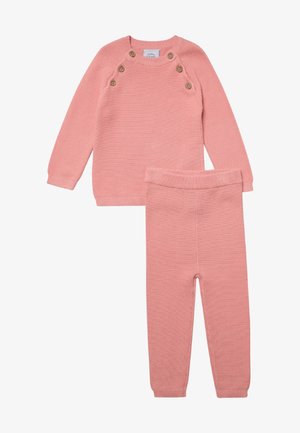 Rosa Strickpullover und passender Hosenanzug. Der Pullover hat einen runden Ausschnitt, gerippte Bündchen und fünf dekorative Knöpfe an der Schulter.