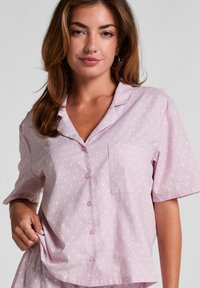 Lichtroze pyjamashirt met korte mouwen, gekenmerkt door een klein wit stippenpatroon, een nietched kraag en een borstzak met roze knopen.