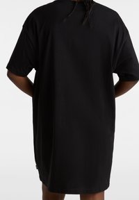 Czarna, oversize koszulka wykonana z bawełny, z krótkimi rękawami i luźnym krojem, z prostym dołem i bez widocznych elementów wzorniczych.