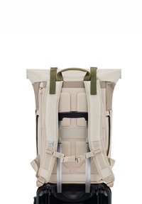 Beige és olíva zöld rolltop hátizsák, párnázott pántokkal, hálós hátrészel és biztosított kerekesszékfogantyú nyílással.