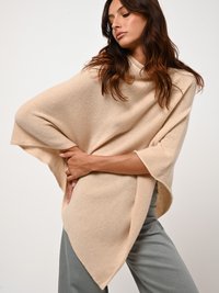 Beige gestrickter Poncho mit Stehkragen, weiten Ärmeln und asymmetrischem Saum. Aus weichem, strukturiertem Material gefertigt.