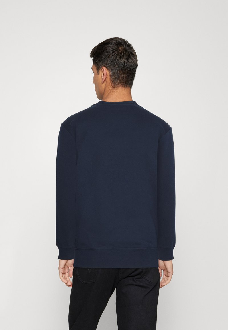 Sweatshirt bleu marine à manches longues et col rond. Présente des poignets et un ourlet côtelés. Le matériau semble lisse et texturé.