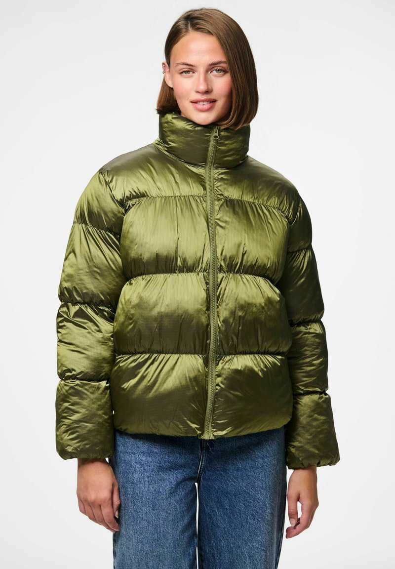 Alyvine žalios spalvos pūkuota striukė su aukštu apykakle, užtrauktuku ir ribota tekstūra. Ypač plačios siuvinėjimo sekcijos ir šiek tiek platėjantys rankovės.