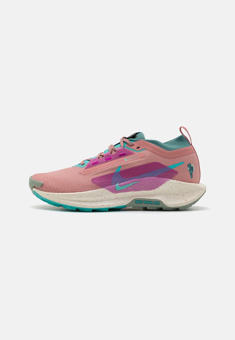 Chaussure de sport rose et bleu-vert avec un dessus texturé, dotée d'un swoosh violet et d'une semelle mouchetée, conçue pour la course en trail.