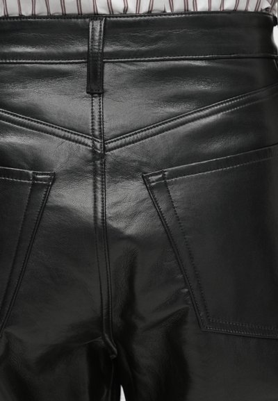 Mustad nahast püksid, millel on sile tekstuur, kõrge vöökoht, dekoratiivsed õmblused ja kaks tagataskut nurkadega klappidega.