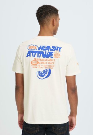 Korte mouw, crèmekleurig T-shirt met levendige blauwe en oranje grafische tekst en fruitmotieven op de achterkant. Katoenen materiaal, relaxte pasvorm.