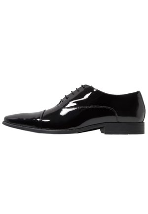 Black patent leather dress shoe with a pointed toe, six eyelets, and a flat rubber sole. Smooth, glossy finish with minimal stitching details.