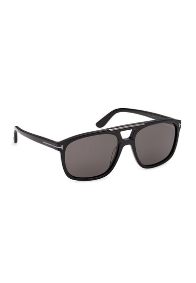 Lunettes de soleil rectangulaires noires avec des verres foncés et de fines touches métalliques sur la monture et les branches, présentées sur un fond blanc.