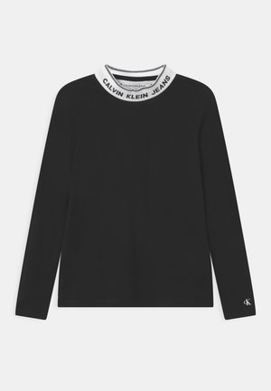 Sort langærmet top med hvid ribkrave med teksten “CALVIN KLEIN JEANS” og lille "cK" logo på venstre ærmekant.