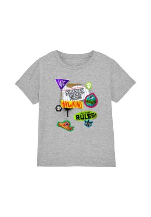 Grey t-shirt with colorful Stranger Things and Hawkins text, cartoon hand, monster eye, skull, and “I make my own rules” speech bubble graphics.