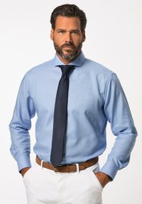 Světle modrá košile s vzorem a dlouhými rukávy, k tomu tmavá kravata. Doplněno hnědým opaskem a bílými kalhotami, což vytváří formální vzhled.