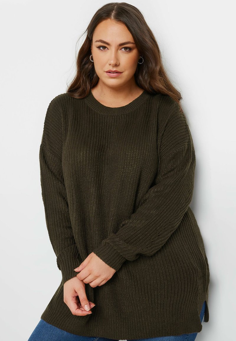 Olivgrön oversized tröja med ribbad textur, rund halsringning och långa ärmar, med sidslitsar och en avslappnad passform.