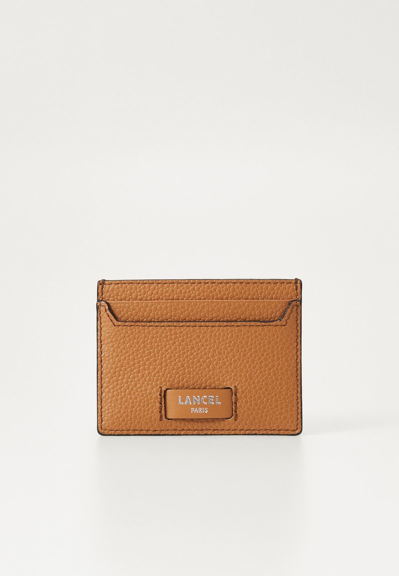 Brun pebble læder kortholder med to kortslots, stikninger i kanterne og en sølv logo plade med teksten "LANCEL PARIS".