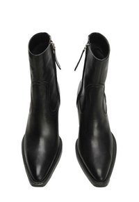 Mustat nahka nilkkurit, joissa on terävä kärki, sivuvetoketjukiinnitys ja sileä pinta. Varusteena kestävä pohja ja huomaamattomat ompeluyksityiskohdat.