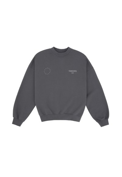 Sweatshirt gris foncé avec un col rond, design à épaule tombante et poignets côtelés. Présente un petit logo circulaire et du texte sur le devant.