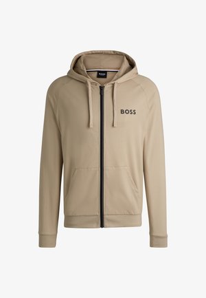 Beige zip-up hoodie met een zwart logo op de borst, voorzakken en een verstelbare capuchon met trekkoord. Glad stof en geribde manchetten.
