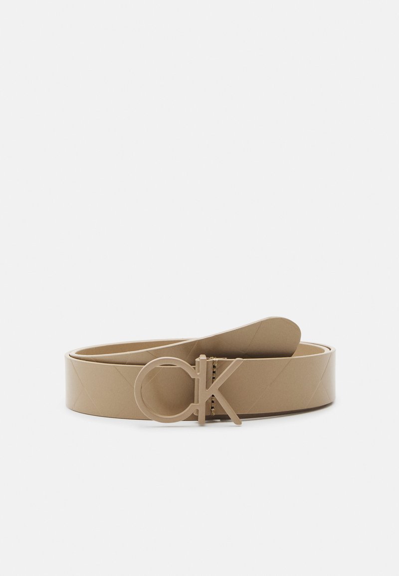 Beige faux leren riem met een grote CK-logo gesp, een gladde textuur en een gewatteerd patroon langs de band.