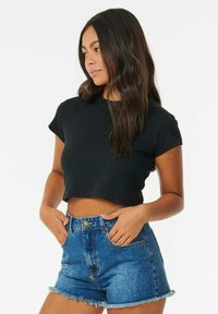 Zwarte cropped t-shirt met korte mouwen, gecombineerd met hoge taille blauwe denim shorts met een rafelige zoom en voorzakken.