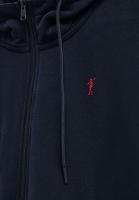 Navyblå hættejakke med lynlås og snore, der har en lille rød broderet polo-spillerlogo på brystet.