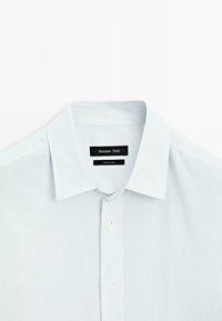 Lichtblauw gestreept overhemd met knopen en een klassieke kraag, gladde textuur en witte knopen. Merkenlabel zichtbaar binnen de kraag.