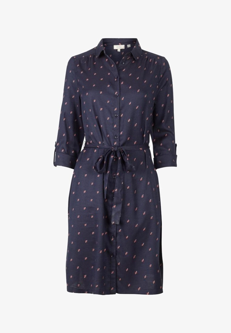 Robe chemise bleu marine longueur genou avec petits motifs floraux rouges, fermeture boutonnée devant, manches 3/4 et ceinture nouée à la taille.