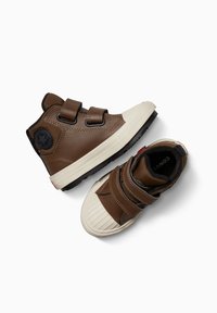 Braune Leder-Hochschnitt-Sneaker mit zwei Klettverschlüssen, cremefarbenen Gummispitzen und schwarzen Gummisohlen, die ein Stern-Logo an der Seite zeigen.