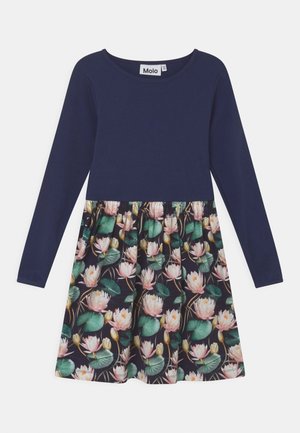 Robe bleu marine à manches longues avec une jupe fleurie présentant des fleurs de lotus roses et des feuilles vertes. L’étiquette indique "Molo."