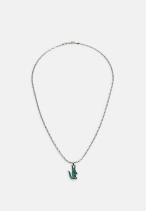 Collier en chaîne argenté avec un charme en émail vert en forme de crocodile et des accents rouges, d'une texture lisse et au design contemporain.