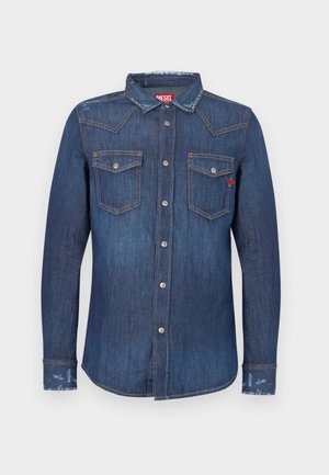 Dark blue denim shirt with long sleeves, pointed collar, two chest pockets, silver button closures, and subtle distressed accents.