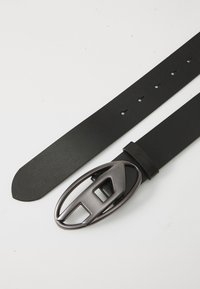 Black leather belt with a smooth, matte finish and a rounded, metallic buckle featuring a cut-out design. Three adjustment holes included.