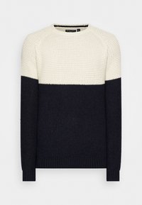 Pull à col rond tricoté avec un design bicolore crème et marine. Comprend un tissu texturé ainsi que des poignets et un ourlet côtelés.
