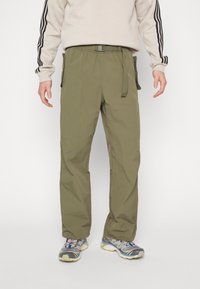 Olivgröna cargobyxor med elastisk midja, skärpknäppning och sidfickor. Tillverkade av lättviktsmaterial och har en rak benform.