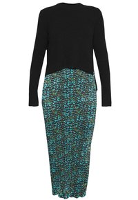 Svart hög croppad tröja som matchar en lång klänning med ett turkos- och grönt abstrakt mönster, gjord av lätt, texturerad tyg.