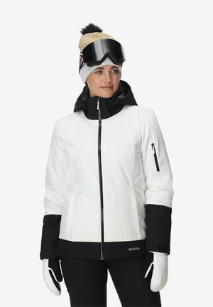 Witte en zwarte ski-jas met ritssluiting, twee zijzakken en een zwarte capuchon. Het model draagt een beige muts en grote zwarte skibril.