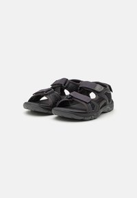 Sorte ute sandaler med justerbare borrelåser, mesh-paneler for pusteevne, og en teksturert gummisåle for godt grep.