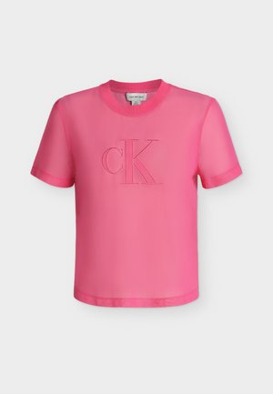 Kirkkaan vaaleanpunainen lyhythihainen paita pyöreällä pääntiellä ja kohokuvioidulla "cK"-logolla rinnan keskellä yksivärisellä taustalla.