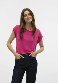 Fuchsia shirt met korte mouwen, met een ontspannen pasvorm, een gladde textuur, ronde halslijn en gedragen met high-waisted donkere spijkerbroek.