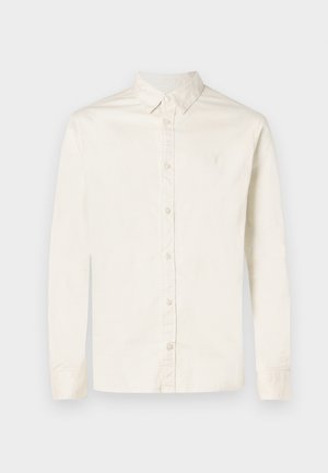 Men's long-sleeve off-white button-up shirt with pointed collar and subtle embroidered logo on the left chest.