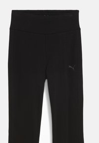 Pantaloni sportivi neri realizzati in un tessuto elastico. Presentano una cintura ampia, una vestibilità slim e un piccolo logo sul lato sinistro.