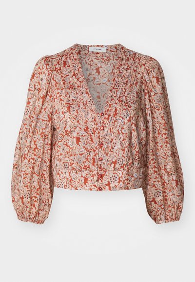 Bluse med blomsterprint i rød og kremfarge, med dyp V-hals, pufferm og knappelukking foran. Lett, teksturert stoff.