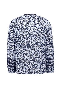 Chemise à manches longues avec un motif floral à fleurs de marguerite bleu et blanc sur l'ensemble du tissu, et un bord en dentelle bleu foncé aux manches et au col.