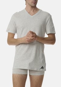 Gray cotton V-neck T-shirt with short sleeves, relaxed fit, and black logo. Paired with matching gray boxer briefs, minimal design.