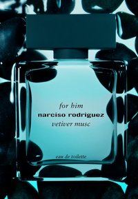 Bouteille en verre transparent de parfum Narciso Rodriguez Vetiver Musc, avec un bouchon carré noir mat et un texte élégant sur fond turquoise.