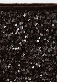 Tissu noir orné de sequins ronds brillants, créant une surface texturée. Le design présente des sequins de tailles variées, disposés de manière dense.