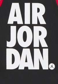 Czarny top z siateczki z dużym, białym napisem "AIR JORDAN" oraz małym logo Jumpman w dolnym prawym rogu.