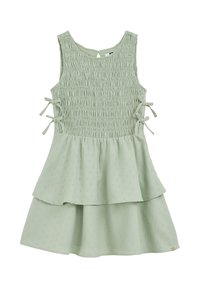 Šviesiai žalia suknelė su smulkintu kūnu, trumpomis rankovėmis ir šoninėmis juostelėmis. Suknelė turi daugiasluoksnį sijoną su tekstūriniu raštu visame paviršiuje.