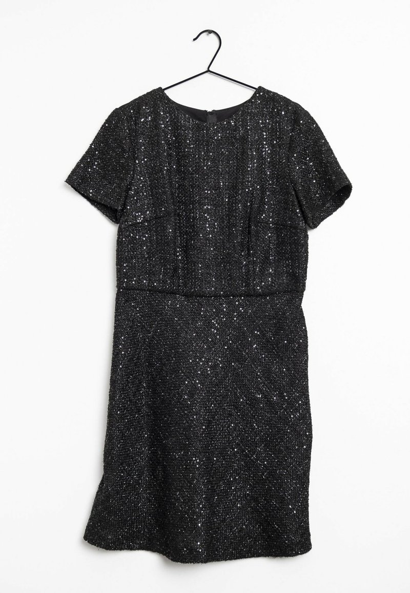 Robe noire à manches courtes avec une texture pailletée, suspendue à un cintre noir sur un fond blanc.