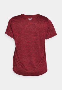 Červený sportovní tričko s krátkým rukávem, vyrobené z texturované tkaniny. Na zadní straně, na horní části, se nachází malé logo. Klasický design s kulatým výstřihem.