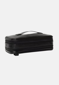 Custodia da viaggio nera, rettangolare, con una texture liscia, doppie cerniere e una maniglia superiore. Design compatto con dettagli di cucitura sottili.