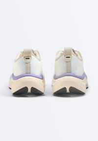 Paire de baskets en mesh crème avec des accents beige et violet et des semelles en caoutchouc noir, vues de dos sur fond blanc.